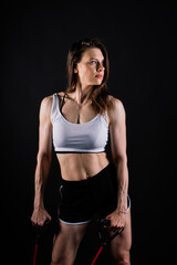 Fototapeta premium Athletic female performs exercises using a resistance band. Strength and motivation