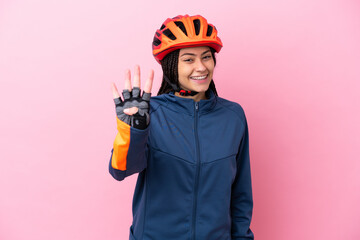 Teenager cyclist girl isolated on pink background happy and counting four with fingers
