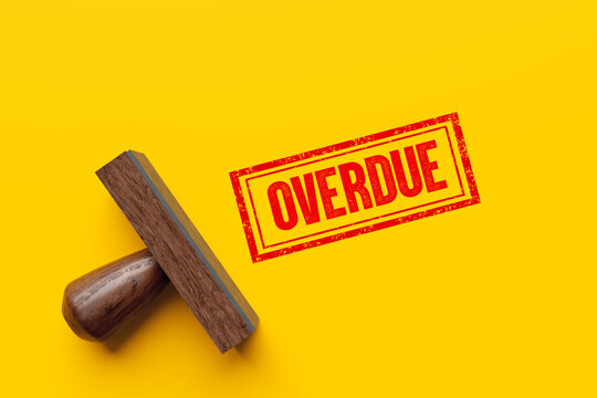 Wooden stamp imprints overdue sign on yellow background