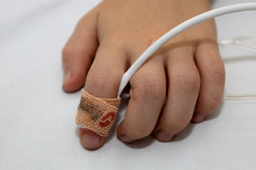 A close-up of a child's hand with a pulse oximeter. Measurement of saturation. A child in the...