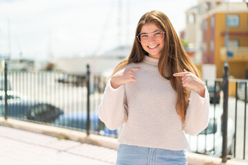 Fototapeta premium Young pretty caucasian woman with glasses at outdoors with surprise facial expression