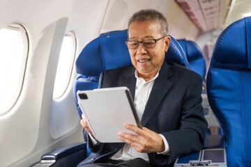 Fototapeta premium An adult male businessman sits by the window on a passenger plane, eager to travel abroad. He gazes at the clouds, anticipating new experiences and adventures in a foreign land.
