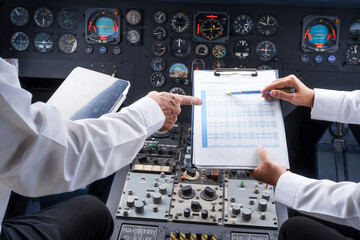 Mature male and female pilots meet inside an airplane, holding hands. Their gesture signifies teamwork, trust, and camaraderie in aviation, fostering a safe and collaborative work environment. © NanSan