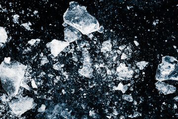 Ice, crushed on a black background. Pieces of crushed ice spread away. Crushing of the ice.