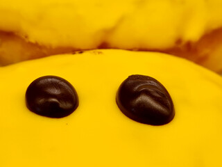 Yellow glazed donut with sprinkles isolated. Close up of colorful donut.
