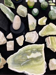 natural jade stones lie on a dark table surface. fair of stones, amulets and talismans according to...