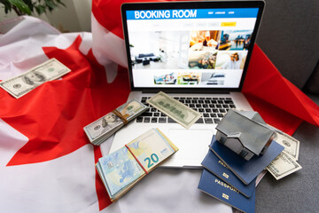 laptop with travel, money and canada flag