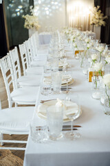 Elegant neutral coloured wedding table scape with flowers and candles