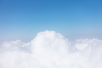 Scenic sky view from airplane with fluffy clouds. Sky is blue and the clouds are white