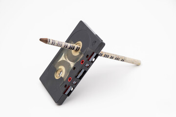 Old music magnetic cassette and wooden pencil on white background