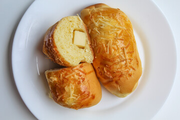 Cut bread with cheddar cheese cube inside, isolated on white background, flat lay or top view