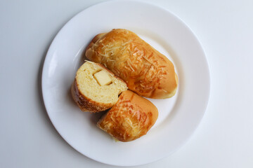 Cut bread with cheddar cheese cube inside, isolated on white background, flat lay or top view