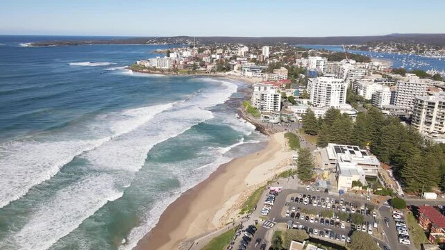 Aerial drone view of Cronulla beach in the Sutherland Shire, South Sydney, NSW Australia during high surf conditions on a sunny morning on 14 July 2024 heading toward Cronulla rock pools   