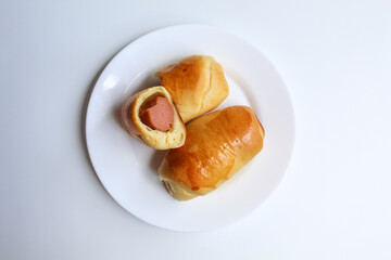 Cut bread with sausage inside, isolated on white background