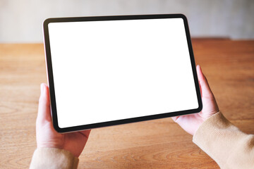 Mockup image of a woman holding digital tablet with blank white desktop screen