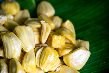 Background image of jackfruit being peeled off to be eaten.