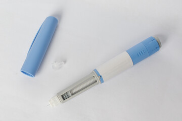 Blue Self injection pen with  insulin or semaglutide macro on white background. Medication,...