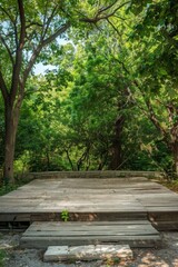 A rustic, empty outdoor stage surrounded by trees, with a wooden platform and a simple backdrop. 