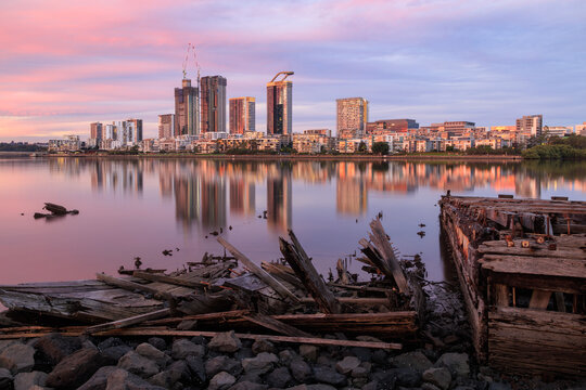 Homebush Bay, Sydney, Australia, at sunset. A view of the suburb of Rhodes with a wrecked barge in the foreground