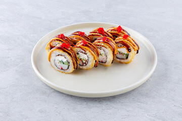 Hot sushi roll with surimi, cucumber and cream cheese, poured with spicy and unagi sauces, garnished with masago caviar