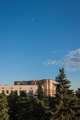 Obraz premium View from the window to the street with high-rise buildings. Houses on the background of the blue sky