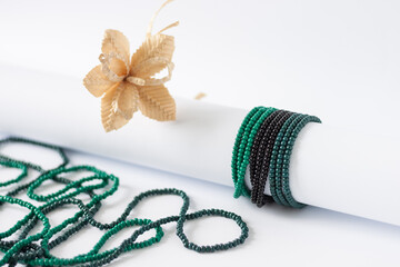 A necklace and bracelets of green and black beads on a white background