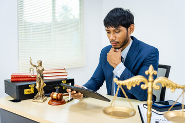 A male Asian lawyer in a formal suit handles contracts, agreements, legal obligations, and considerations of rights and liberties, focusing on constitutional and human rights in legal practice.