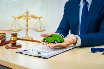 A male Asian lawyer in a formal suit works at his desk, focusing on contracts and legal matters,...