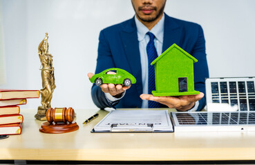 A male Asian lawyer in a formal suit works at his desk, focusing on contracts and legal matters,...