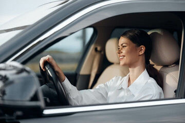 Woman, car, driver, steering wheel, smile a cheerful woman sits in the driver's seat of a car, her...