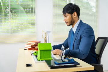 A male Asian lawyer in a formal suit works at his desk, focusing on contracts and legal matters,...