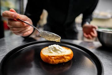 Close-up of a hand spreading creamy substance on toasted bread