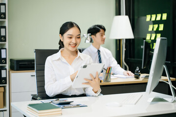 Business woman using tablet and laptop for doing math finance on an office desk, tax