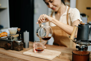 Asian barista brewing fresh espresso. Enjoy a cozy, trendy cafe experience with high quality beans in home or cafe
