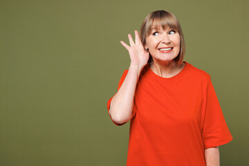 Elderly curious nosy blonde woman 50s years old she wear orange t-shirt casual clothes try to hear...