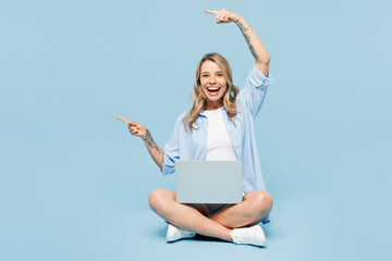 Full body surprised young IT woman wears white top shirt casual clothes sits hold use work on...