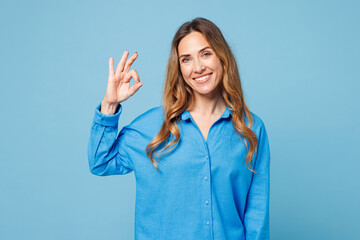 Young smiling happy cheerful satisfied woman she wear shirt casual clothes showing okay ok gesture...