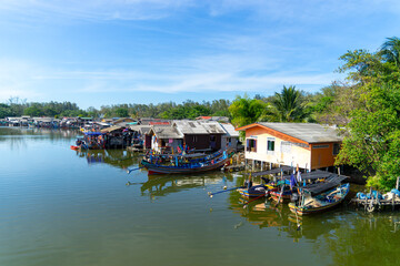 Colorful local fishing boats behind houses along the river