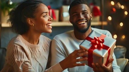 Happy couple exchanging gifts with smiles and excitement on their faces.