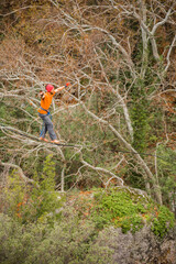 A man walks on a tightrope over an abyss.