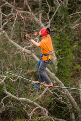 A man walks on a tightrope over an abyss.