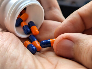 Picking up an Omeprazol pill in his hand, several pills spilling out of a bottle
