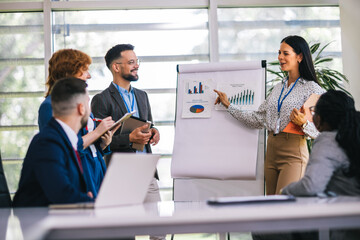 Multiracial businesss people showing their colleagues diagrams and graphics on a business meeting....