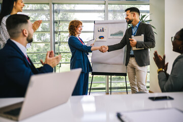 Business man from Human Resource congratulates the new  ginger employee of their company after the...