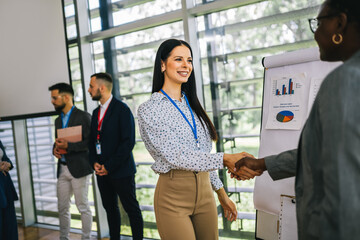 Business woman from Human Resource congratulates the new African American employee of their company after the job interview.