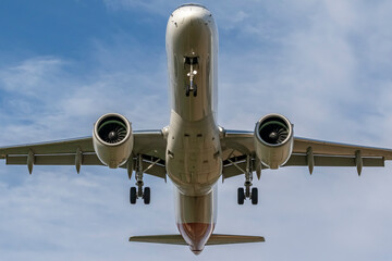 airplane in the sky about to land on a sunny day