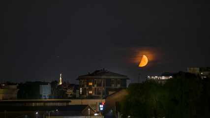 Fototapeta premium luna rossa di notte con vista della madonnina del duomo di milano