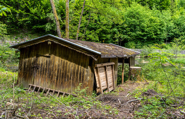 kleiner Teich mit verfallenem Holzschuppen im Wasser, Bad Reichenhall, Bayern, Deutschland