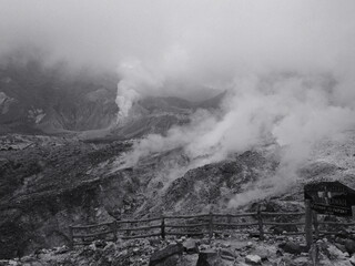 A black and white photo of a mountain with smoke rising from it