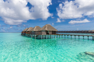 Beautiful sunny tourism destination tropical beach, Maldives. Jetty pathway into tranquil paradise island. Luxury water villas blue sea, perfect summer vacation landscape or holiday beachfront coast